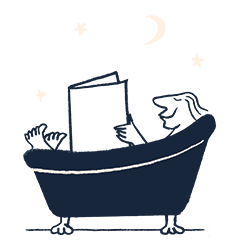 man relaxing in a bath reading a newspaper